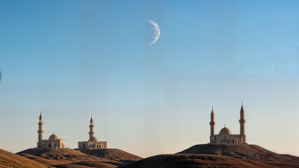 Mosque silhouettes under crescent moon in serene dusk