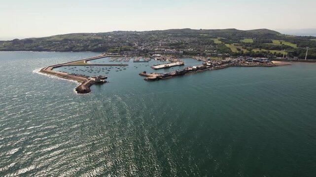Aerial view of the Howth harbour, where the tranquil turquoise water meets the rugged coastline and the verdant landscape, Ireland's Eye Island, County Dublin, Ireland.