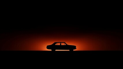 Silhouette of a classic car against a vibrant sunset on a clear horizon