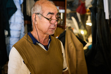 Tailor in glasses in a workshop for tailoring,repairing clothes