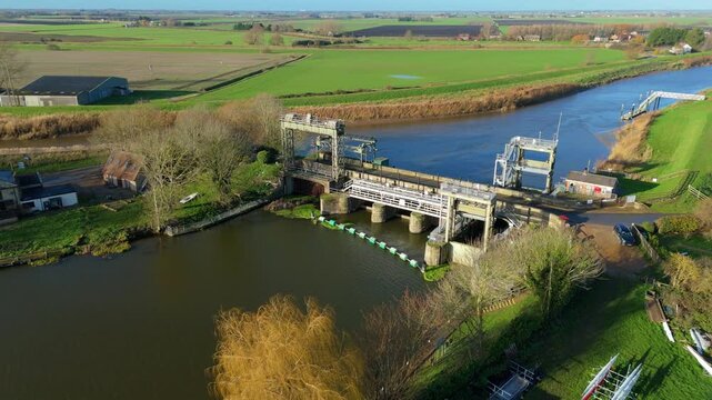 Aerial view of the Denver sluice, a stark contrast between the water and green fields, Downham Market, England, United Kingdom.