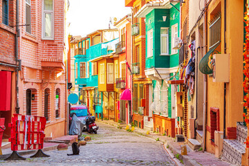 Fototapeta premium Colorful houses in the Balat and Fener districts. The cat is walking along a narrow street.