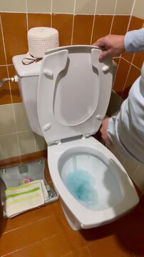 tirando de la cadena del v&aacute;ter inodoro con cisterna en el servico retrete wc del ba&ntilde;o