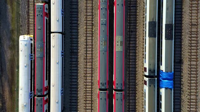 Aerial view of trains with red and white tops stand on multiple parallel tracks in a yard, a symmetrical display of modern transportation, Ely, England, United Kingdom.