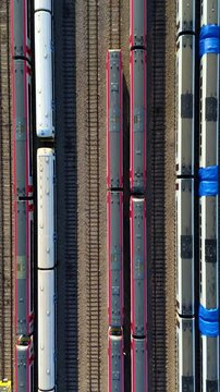 Aerial view of colorful trains standing on the parallel tracks, creating a striking visual pattern of lines and rectangles, Ely, England, United Kingdom.
