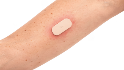 Closeup of a wearable skin temperature patch attached to an adults lower leg showcasing a small sensor on white background with a focus on inflammation monitoring.