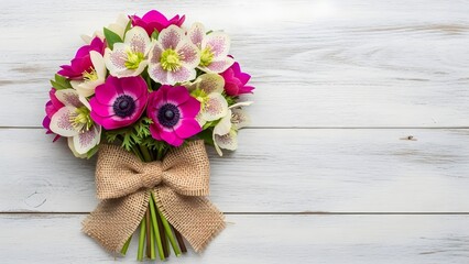 A beautiful bouquet of pink and white flowers tied with a burlap ribbon on a rustic white wooden background, showcasing nature's elegance with plants and flowers.