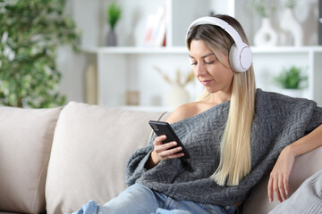 Serious woman wearing headphone watching online content