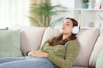 Woman in green sleeping wearing headphone on a couch