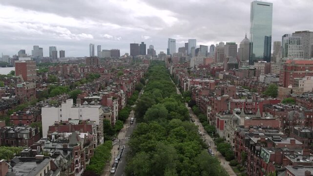 Aerial view of Commonwealth Avenue's lush green trees contrasting with the brick buildings and the modern skyline, Boston, Massachusetts, United States.