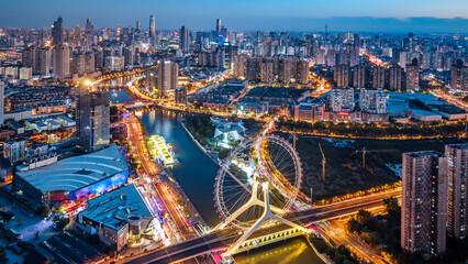 Aerial night view of the Tianjin Eye Ferris wheel over the Haihe River in Tianjin, China