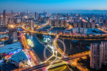 Fototapeta premium Aerial night view of the Tianjin Eye Ferris wheel over the Haihe River in Tianjin, China