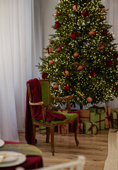 A bright room with a window and a decorated Christmas tree in the corner