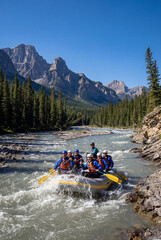 Group of people white water rafting through mountain river rapids. Concept of teamwork, adventure travel and outdoor excitement.