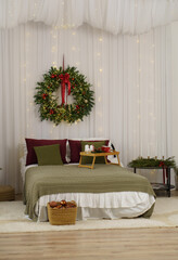 A large bed with a green bedspread is decorated for the New Year.