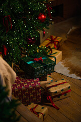 A decorated New Year's tree with lights shining in the evening in a dark room
