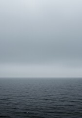 Obraz premium A vast, chilling, and atmospheric scene of dense gray mist rolling over the open water where the horizon vanishes completely ,environment ,water ,abstract
