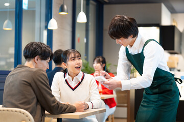 カフェで注文をする若い男女