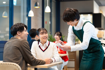 カフェで注文をする若い男女