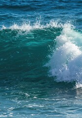 Naklejka premium Dynamic close-up view of a vibrant blue ocean wave breaking in the sunlight, creating white foam and mist during the hot summer season ,nature ,close-up ,ocean