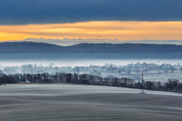 OLYMPUS DIGITAL CAMWinter morning in Zabierz&oacute;w near Krakow. Frosted fields and misty valley with a plane taking off from Balice Airport against the breathtaking backdrop of the snowy Tatra MountainERA
