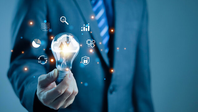 Businessman holding light bulb with cloud computing and technology icons, representing innovation, digital transformation, data security, smart solutions, cloud technology, and modern business ideas. - Powered by Adobe