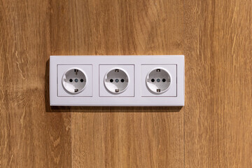 Triple Electrical Power Outlet on Wooden Wall Interior