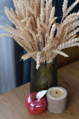 Close up detail of rustic wheat bouquet in vase on wooden table. Selective focus. Low DOF.