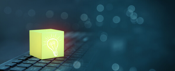 Idea concept with glowing light bulb icon on computer keyboard
