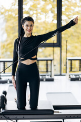 Woman trainer exercising on pilates reformer