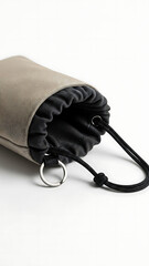 Close-up of a beige fabric drawstring pouch with a dark lining and a metal ring on a white background.
