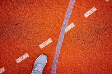 Dynamic sports environment with decision focus, Athlete at crossroads on vibrant red sports surface