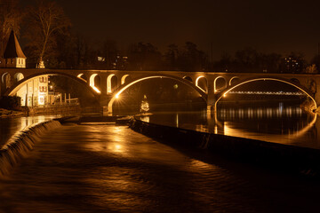 illuminated railroad bridge of Bremgarten is reflecting in the Reuss river
