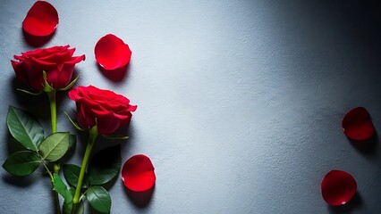 Red roses with scattered petals on soft gray fabric background
