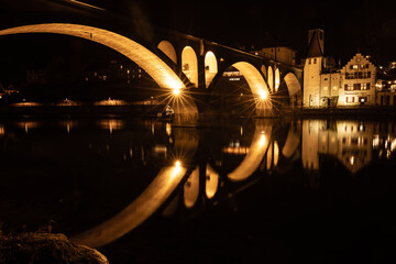 illuminated railroad bridge of Bremgarten is reflecting in the Reuss river