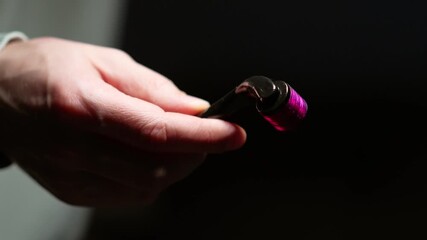 Dermaroller for skin tightening and micro-needling.
Cosmetic procedures and skin care.
A cosmetologist holds a dermaroller with micro-needles.
Using a dermaroller