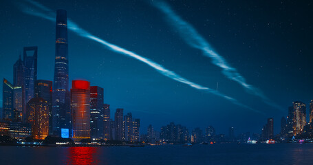 Night starry sky above Shanghai Skyscrapers. reflection of Shanghai's skyscrapers amidst bustling urban life at evening.