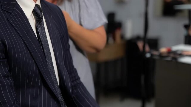Creative professional styling a public figure for a photo shoot focusing on wardrobe and grooming for impactful image packaging.