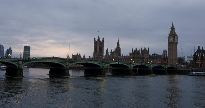 red buses, traffic and people on Westminster Bridge over the River Thames next to Big Ben and The Houses of Parliament, London, England
