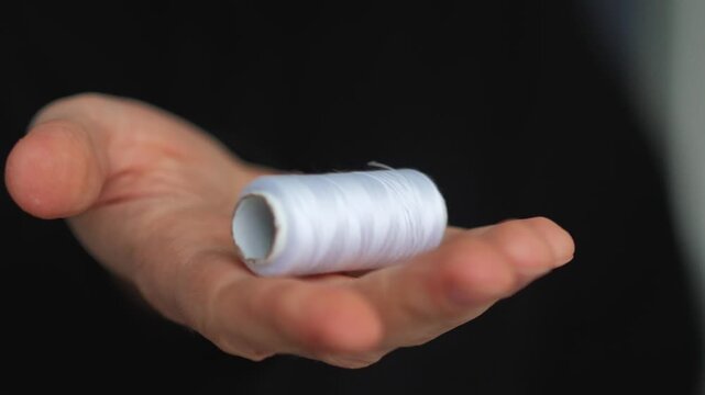 A skein of white sewing thread in a person's hands.
White thread for mending clothes and sewing holes.
Niktei, atelier, repair, clothing, skein, white