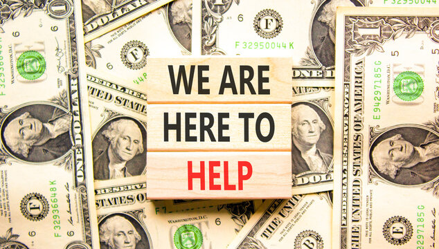 Support, help and we are here to help symbol. Concept words We are here to help on beautiful wooden blocks. Beautiful dollar bills background. Business we are here to help concept. Copy space.