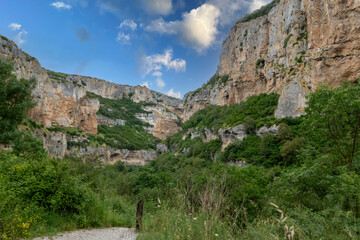 Stunning Canyon Landscape With Cliffs And Greenery Under A Bright Blue Sky at foz du lumbier in spain