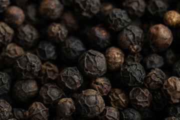 Obraz premium Macro photo of black peppercorns, detailed texture, isolated on a dark background, perfect for cooking, spice, and culinary concepts