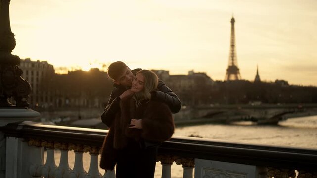 A romantic couple embraces on the Alexandre III Bridge in Paris France during a golden sunset The Eiffel Tower is visible in the background symbolizing love and affection in the city of lights The sce