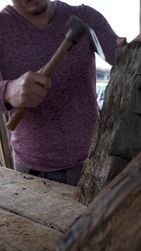 Artisan carving 150 year old chestnut wood with mallet