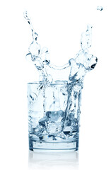 Falling Ice Cubes into the Glass of Water with splash, isolated on white background with natural reflection and shadows