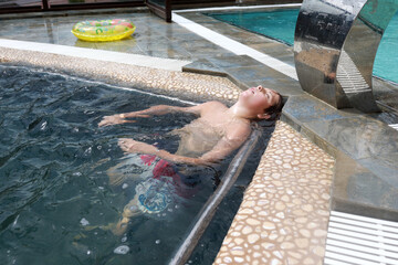 Young caucasian boy relaxing in swimming pool