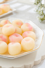 A plate of delicious peach balls on a decorative white plate with a gold rim, perfect for a sweet treat or dessert