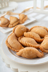 A plate of golden empanadas on a white background, perfect for culinary or cultural concepts