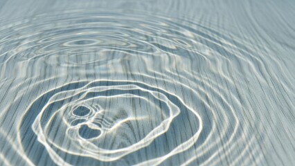 Ripples on the serene water surface, creating concentric circles from a dropped object, captured from a top-down viewpoint.